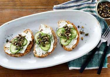 Toast met roomkaas, komkommer en geroosterde pompoenpitten