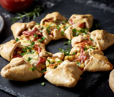 Star shaped pizza with Double Crème White, potatoes, red onion, prosciutto and rosemary