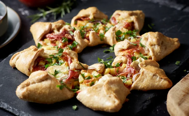 Star shaped pizza with Double Crème White, potatoes, red onion, prosciutto and rosemary