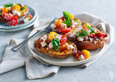 Bakad potatis med vitost, tomater och basilika
