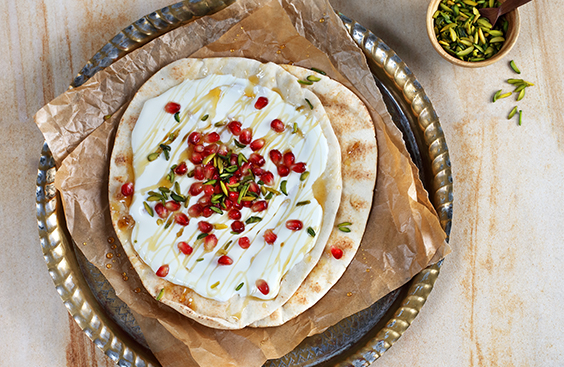Arabic bread with cheese, honey, pomegranate seeds and pistachios