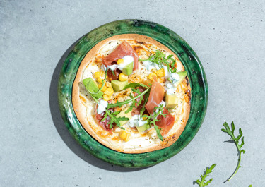 Lactose-free tortilla pizza with serrano ham and rocket