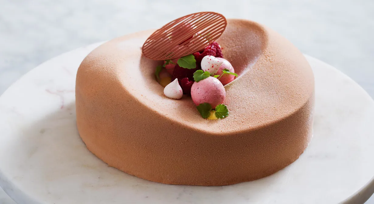 En elegant tårta med fantastiska smaker. Karamelliserad, luftig mjölkchokladmousse varvas med len hallonpannacotta, seg browniebotten och
syrlig passionsfruktcrème. Allt toppat med hallon och sötsyrliga yoghurtmaränger.