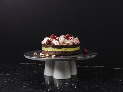 Chokladfudgetårta med pistage, carob och vispad smetana med hallon