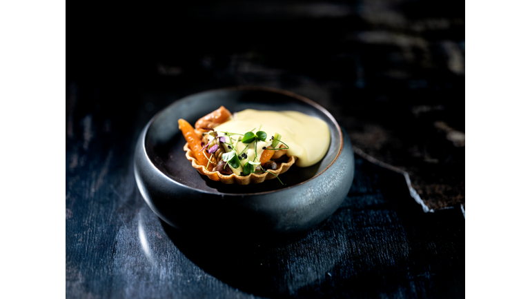 Tærte fyldt med stegte svampe og gulerødder, toppet med brunet smør sifon