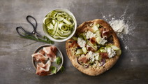 Pizza med hytteost, parmaskinke og basilikum