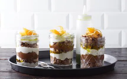 En ljuvlig dessert och ett smakfullt blickfång som säljer. Varva färskostkräm med kolasås och dinkelcrunch i glas. Citronverbenaoljan får sin härliga färg av babyspenat.