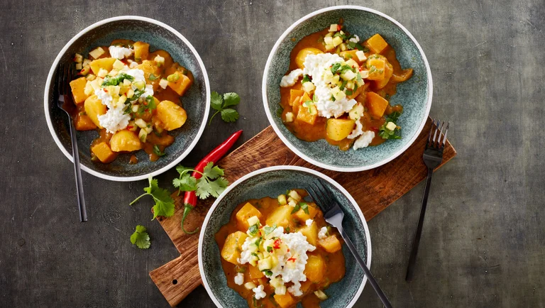 Løg og kartofler i spicy rød karry, toppet med hytteost og ananassalsa