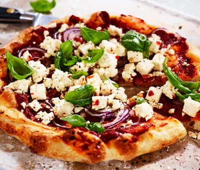 Pizza with tomato, Greek Style Cheese Cubes, and Black Olives