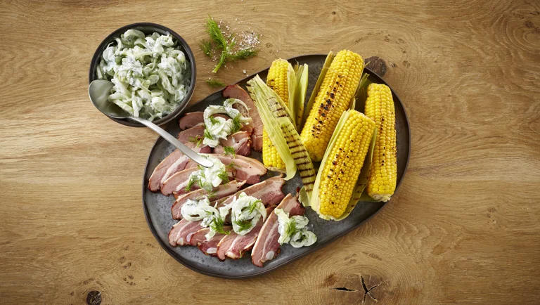 Grillede majs med krondild, røget svinebryst og fennikeltzatziki