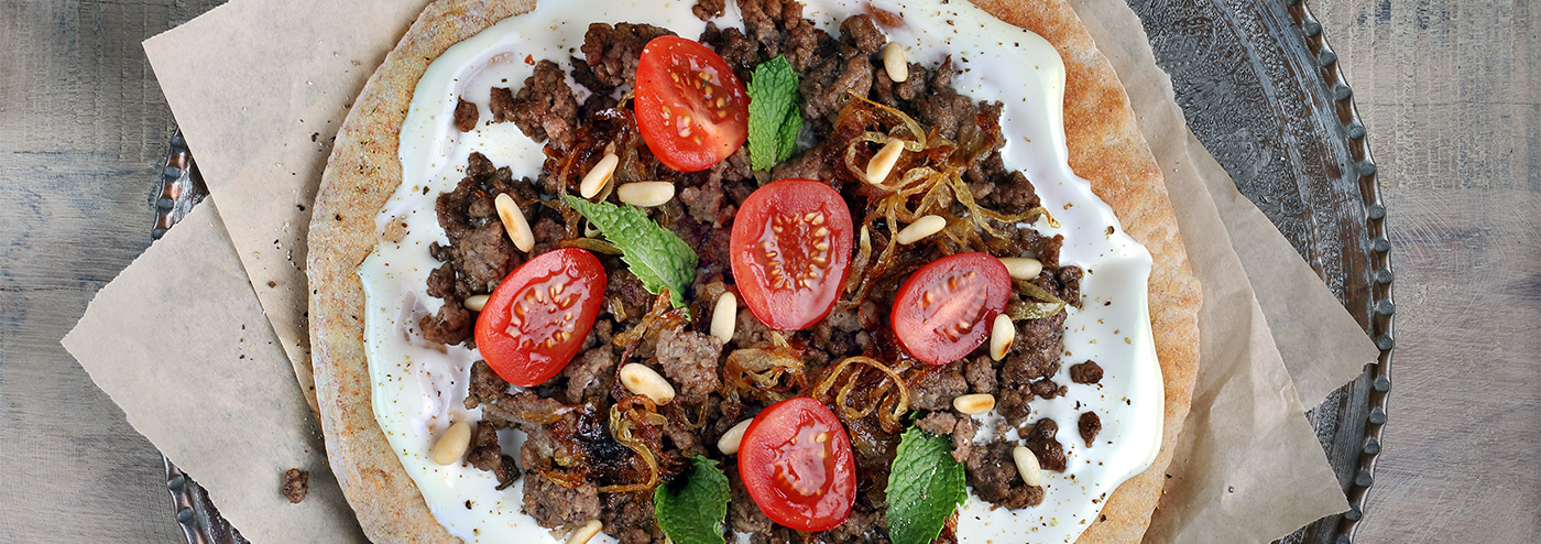 الخبز العربي مع جبنة كريم، اللحم المفروم، البصل المقلي، الطماطم والنعناع