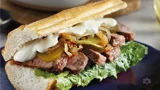 Baguette with steak, pickles and caramelized onions
