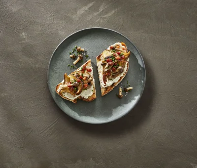 Sourdough bread with Castello® garlic whipped cream cheese, mushrooms, and chives