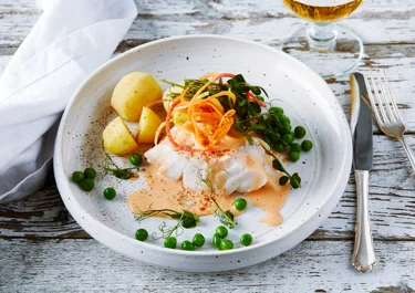 Torsk med morotssås, svarvade morötter, ärter och potatis.