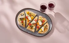 Pinsa with mascarpone, tomatoes, brie, and olives
