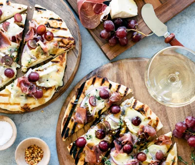 Grilled naan flatbread with grapes, onion jam, prosciutto and Double Creme Cheese