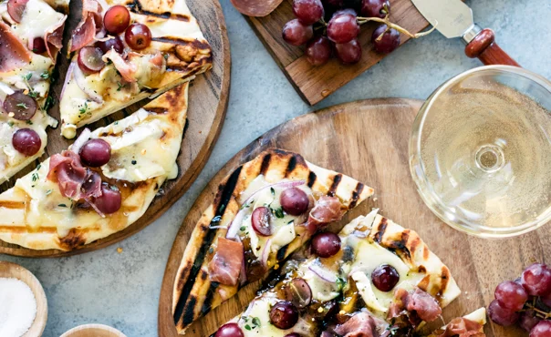 Grilled naan flatbread with grapes, onion jam, prosciutto and Double Creme Cheese