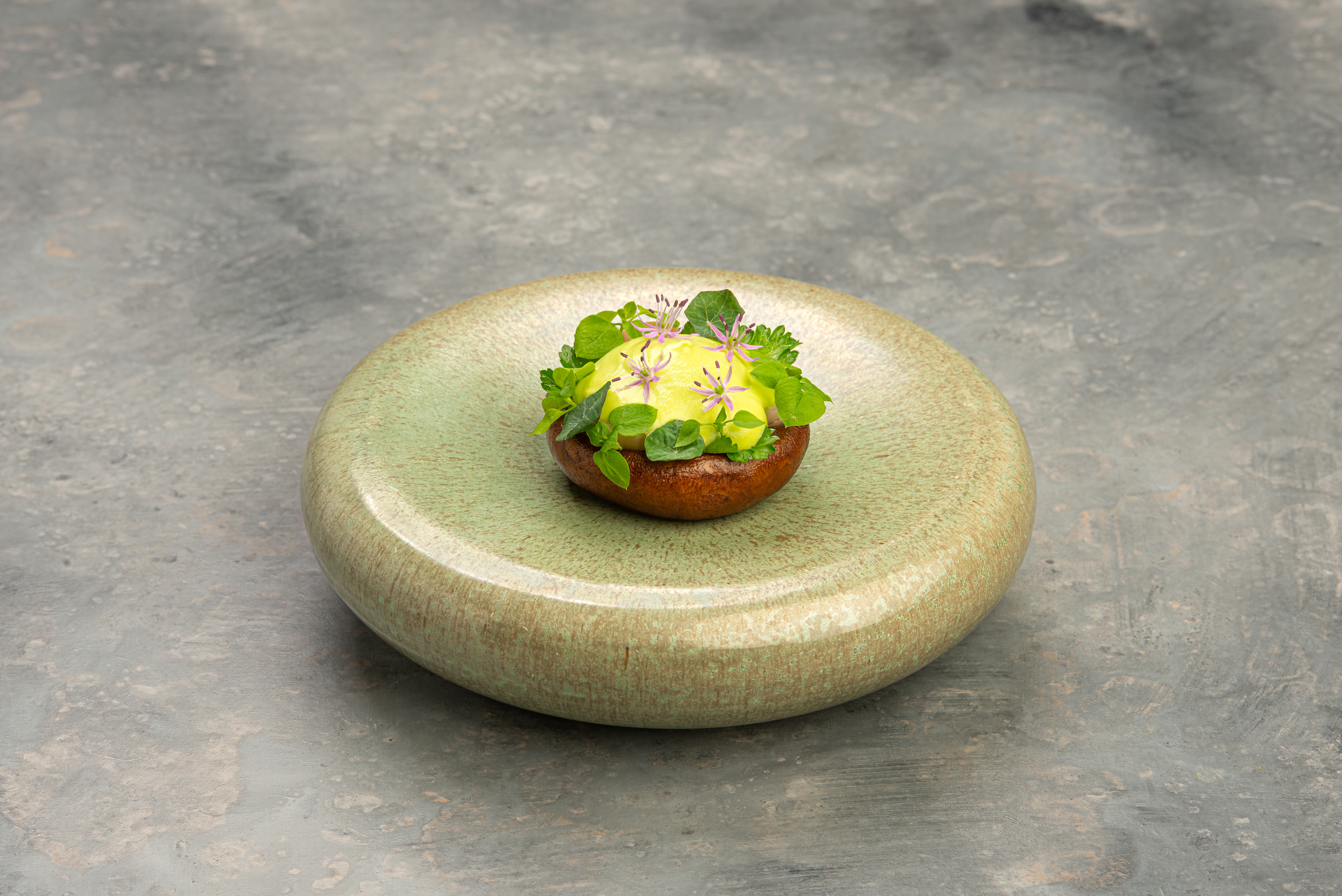 Boter-gebakken champignons met erwtenragout en aardappelschuim