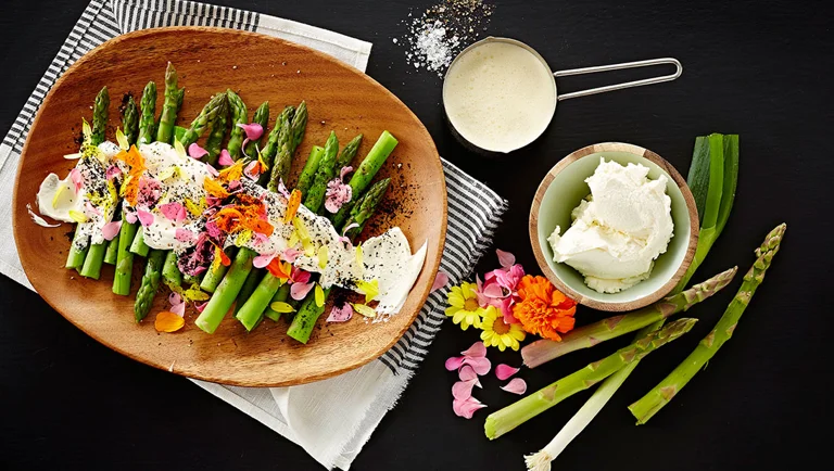 Green asparagus with cream cheese, flowers and charred spring onions