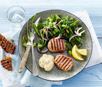 Grilled tenderloin medallions with prosciutto and edamame and bean salad