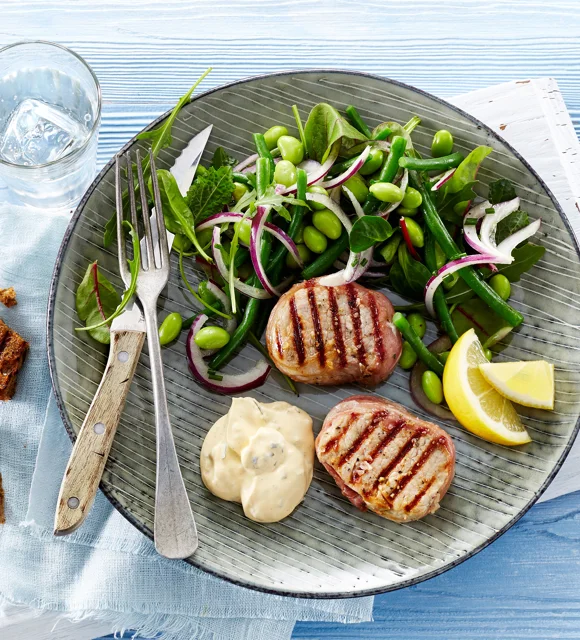 Grilled tenderloin medallions with prosciutto and edamame and bean salad