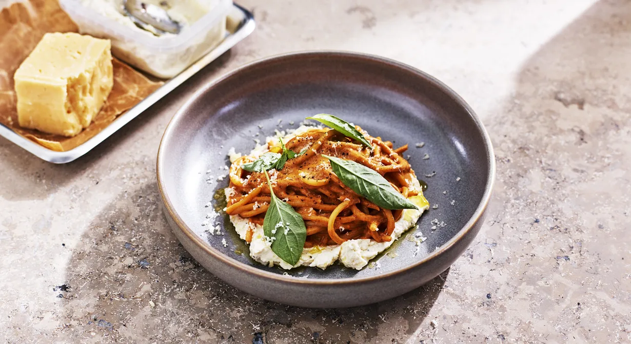 Rostad tomat, rödlök och chili mixas med mandlar till en mustig tomatsås. Enkelt att ha förberett för att sedan vid service blanda tomatsåsen med pasta och en färskostkräm med vällagrad Svecia. Lite färskostkräm breds också på tallriken innan spaghetti med rostad tomat läggs ovanpå. Toppa med riven Svecia och färsk basilika.
Rätten är skapad av Årets Kock 2023, Desirée Jaks.