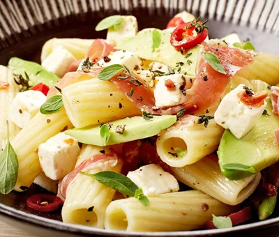 Pasta with sundried tomatoes, avocado, prosciutto and Castello® Greek Style Cheese Cubes