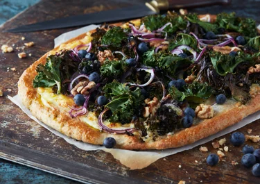 Grönkålspizza med färskost och blåbär