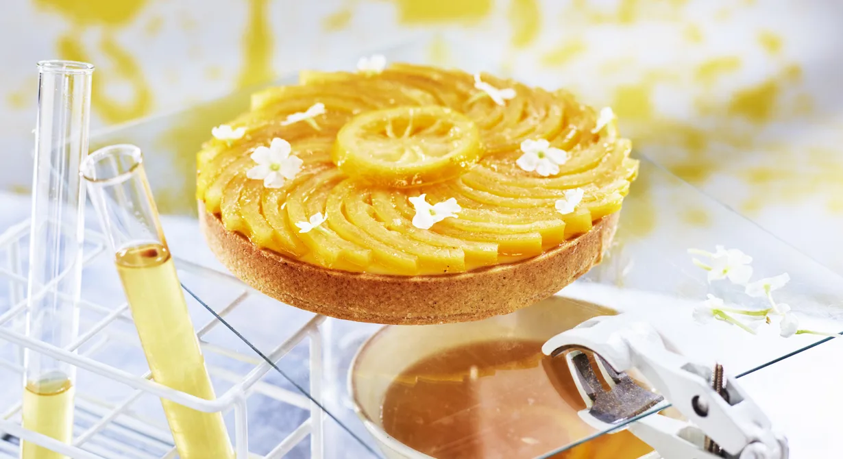 Citrustarten med en botten på dinkel fylls med len och syrlig sudachicurd. På curden läggs skivor av inkokta citroner som fått en blommig touch av fläder.
