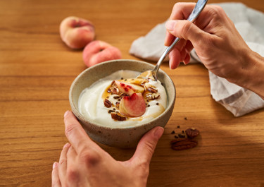 Arla® Skyr Bowl mit Pfirsich, Pekannüssen, Ahornsirup und Kardamom