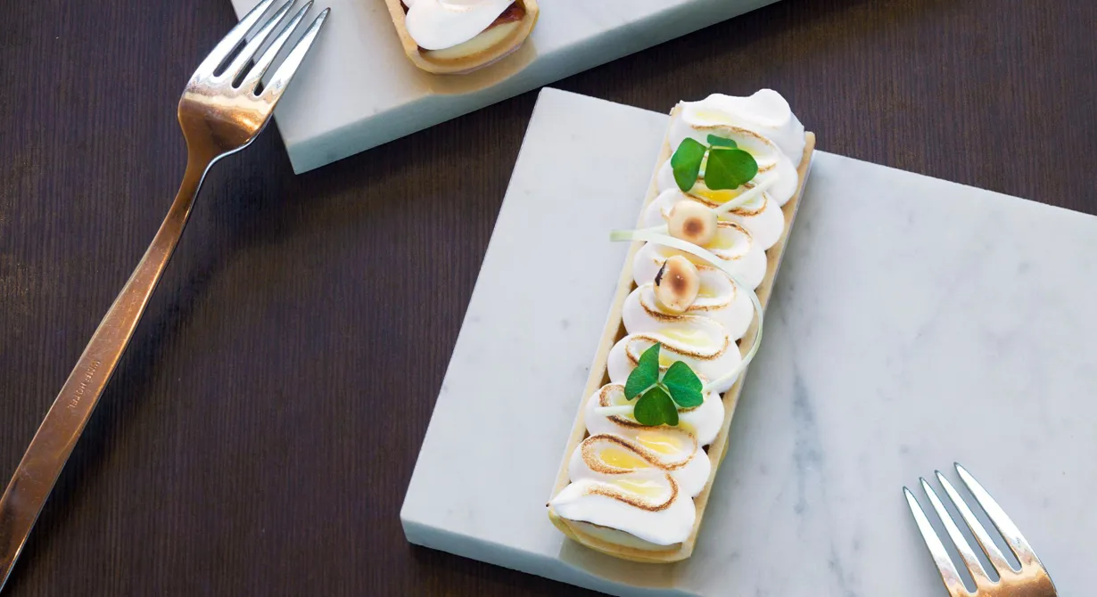 En klassiker i ny design. I perfekta mördegsskal ligger en smakrik citroncrème med krispig nougat inbäddad i italiensk maräng. Droppar av syrlig yuzugelé och rostade
hasselnötter blir som smycken ovanpå.