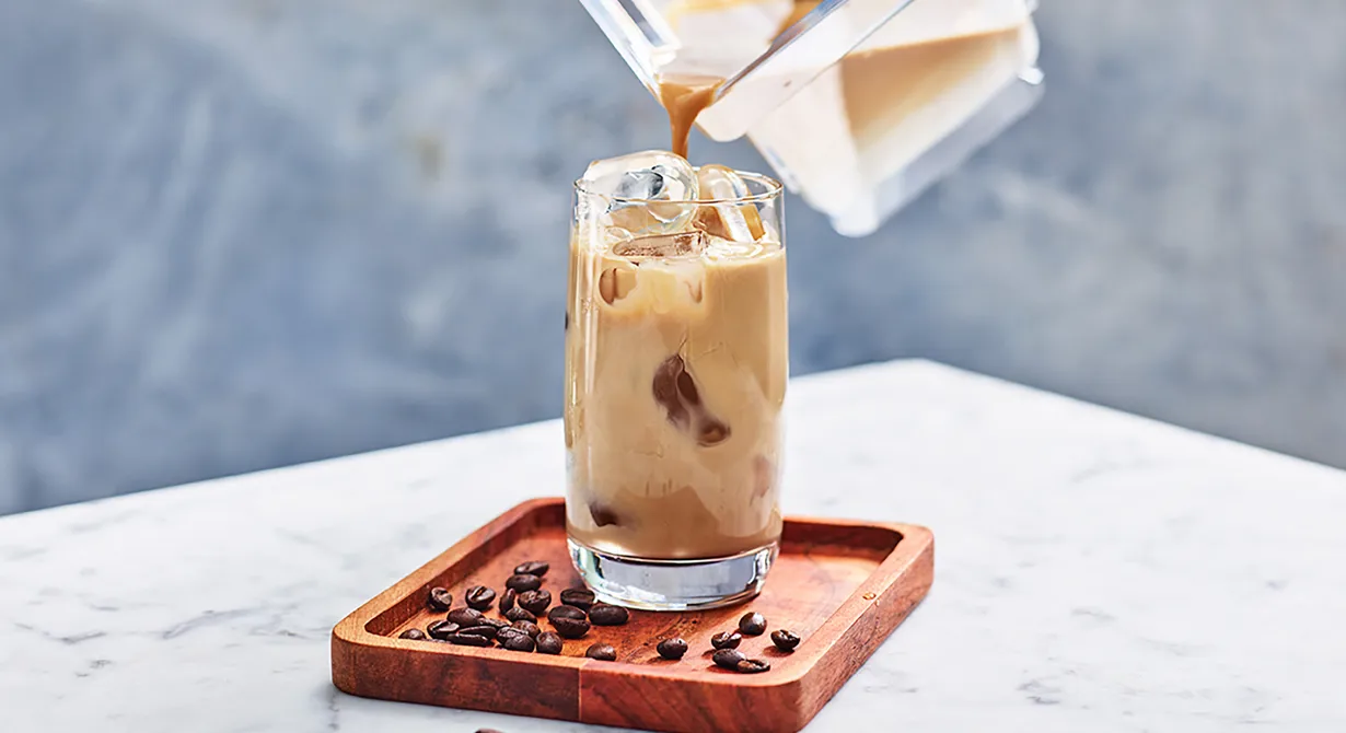 Blanda vaniljmjölk med espresso och häll latten över isen i ett glas. Eller fyll ett glas med is, häll på espresso och därefter vaniljmjölk. Båda sätten är enkla och båda sätten ger en perfekt vaniljlatte!