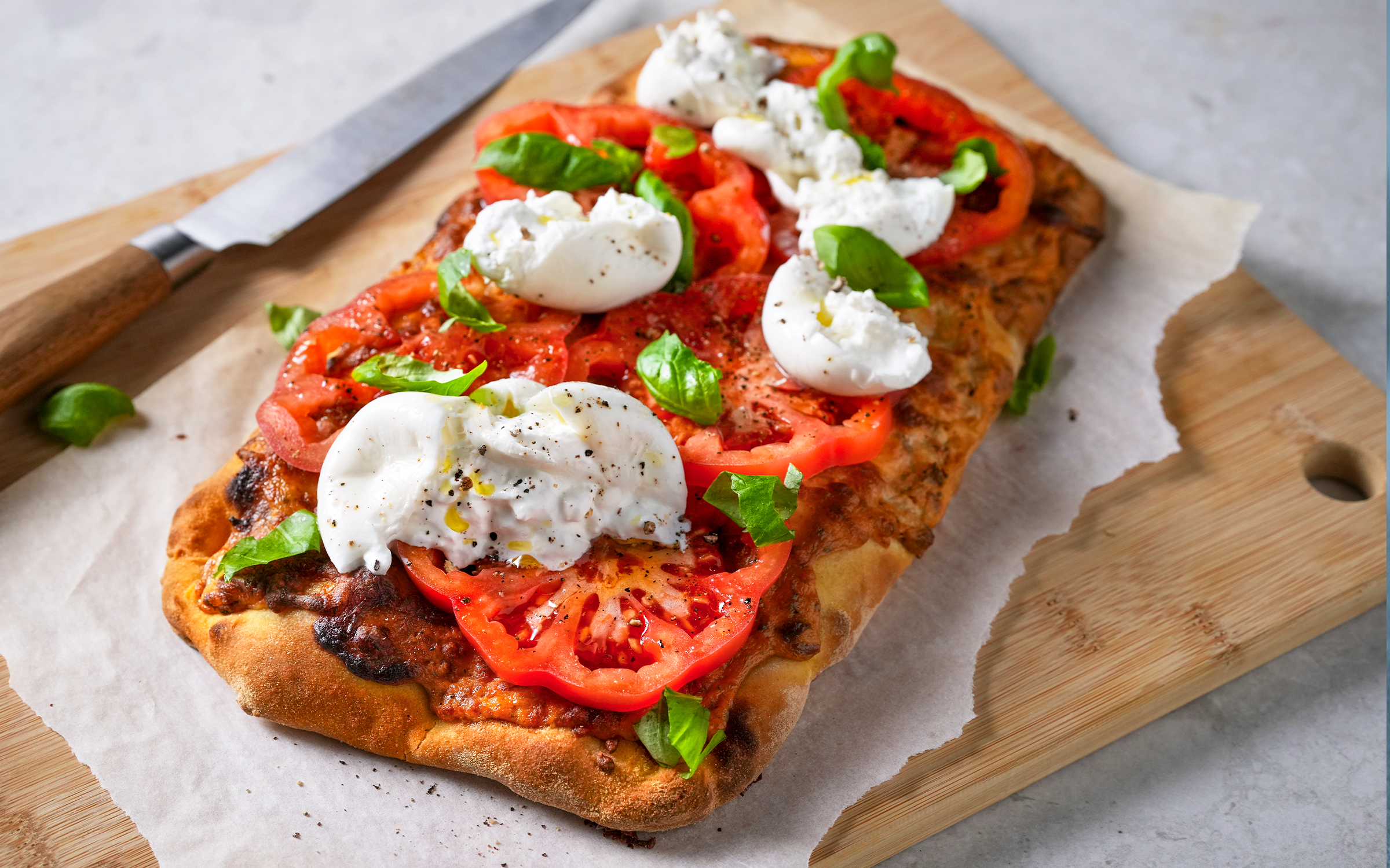 Pinsa med burrata, tomat och basilika