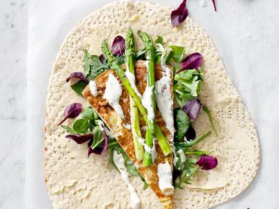 Fantastiskt bröd som rymmer en hel lunch. En läcker kombination med mjuk omelett, grillar sparris och en krämig dressing med sting av vitlök. Wrap betyder att
slå in. Och det är precis vad du gör med fyllningen.