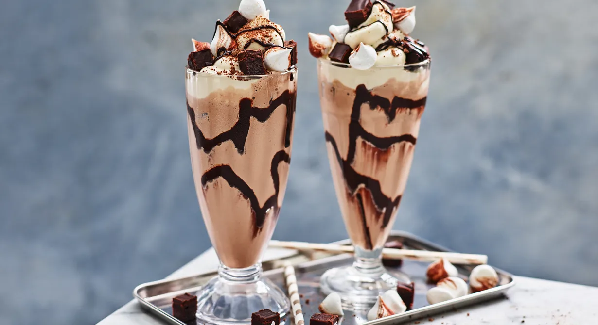 Maxad chokladshake toppad med vispad grädde, små maränger och minibrownies kommer garanterat att bli populär bland gästerna. Den här chokladmilkshaken är aktuell året om, inte bara på sommaren.