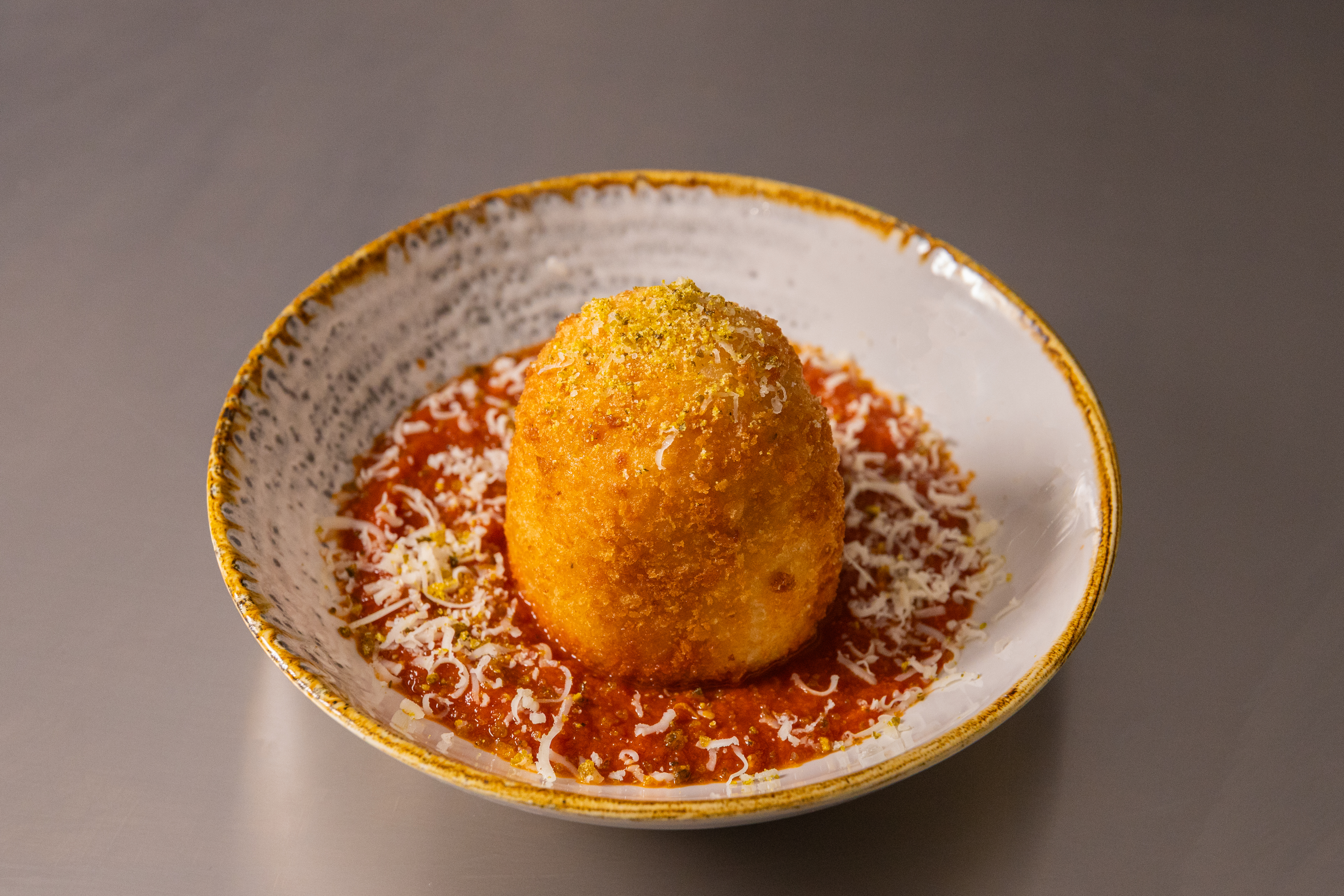 Oversized Mozzarella-Stuffed Arancini with Chipotle Sauce & Pickle Dust
