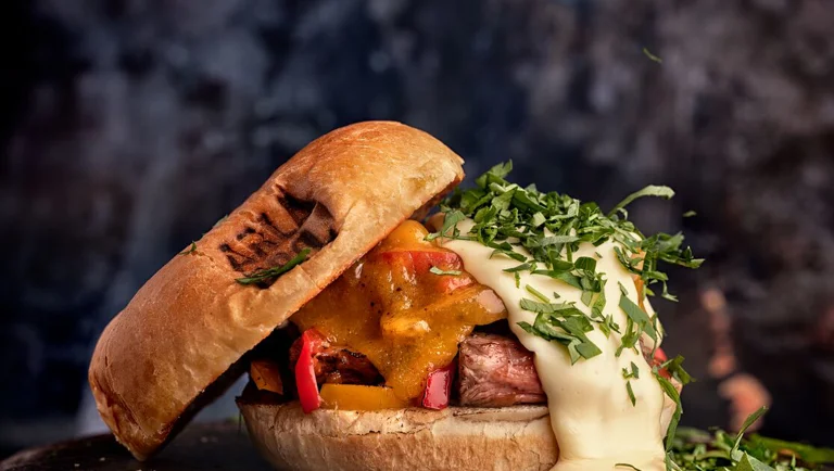 Burger façon Philly Cheese Steak au bœuf, poivrons et sauce cheddar