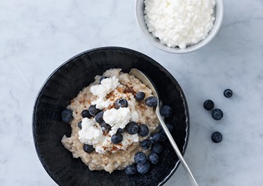 Proteiinipitoinen puuro raejuustolla ja mustikoilla