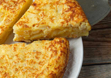 Tortilla de patatas con gambones y queso crujiente