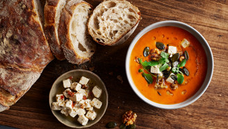 Tomatsoppa toppad med vitost, rostade nötter och färsk oregano